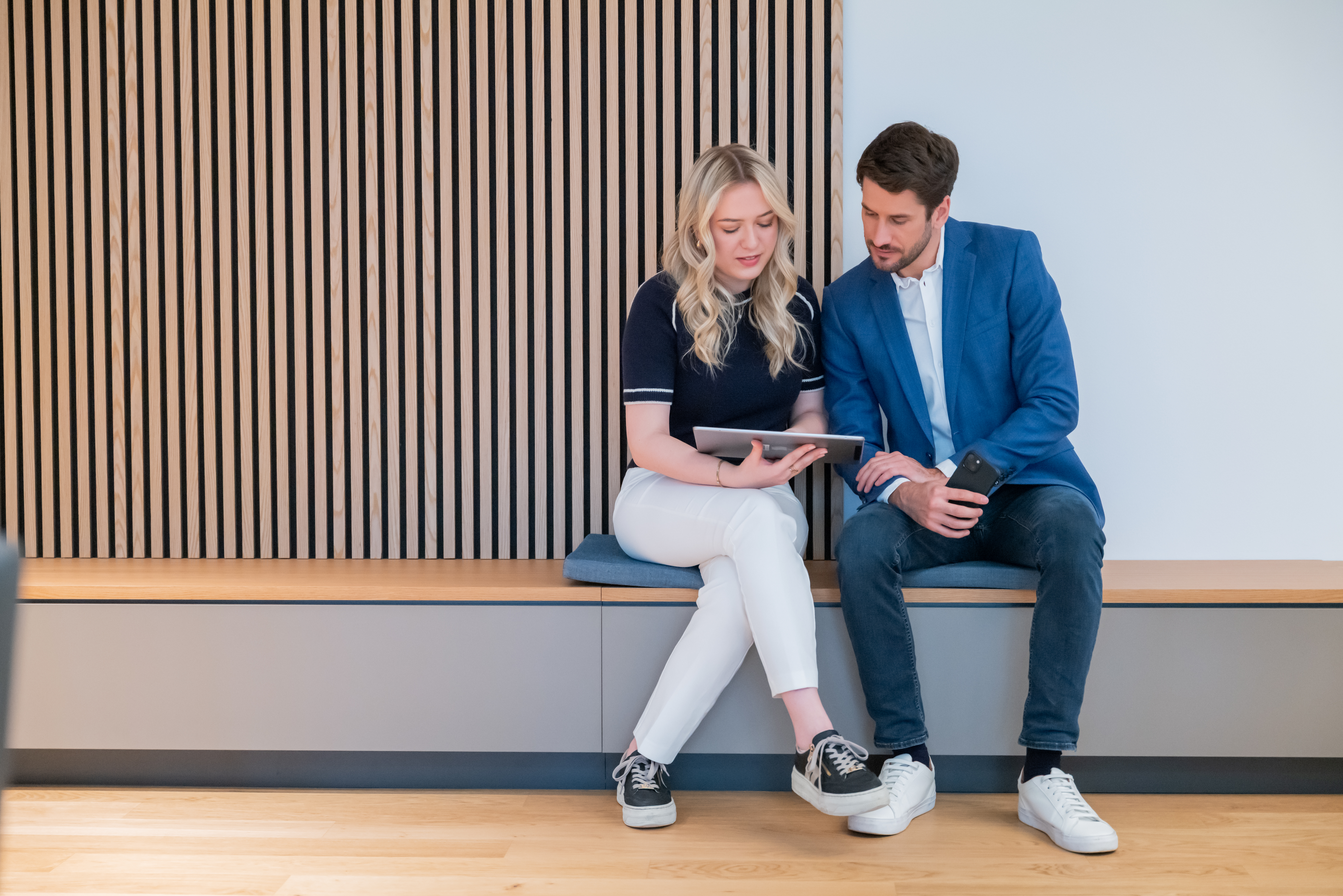 Zwei Personen im Büro schauen auf Tablet