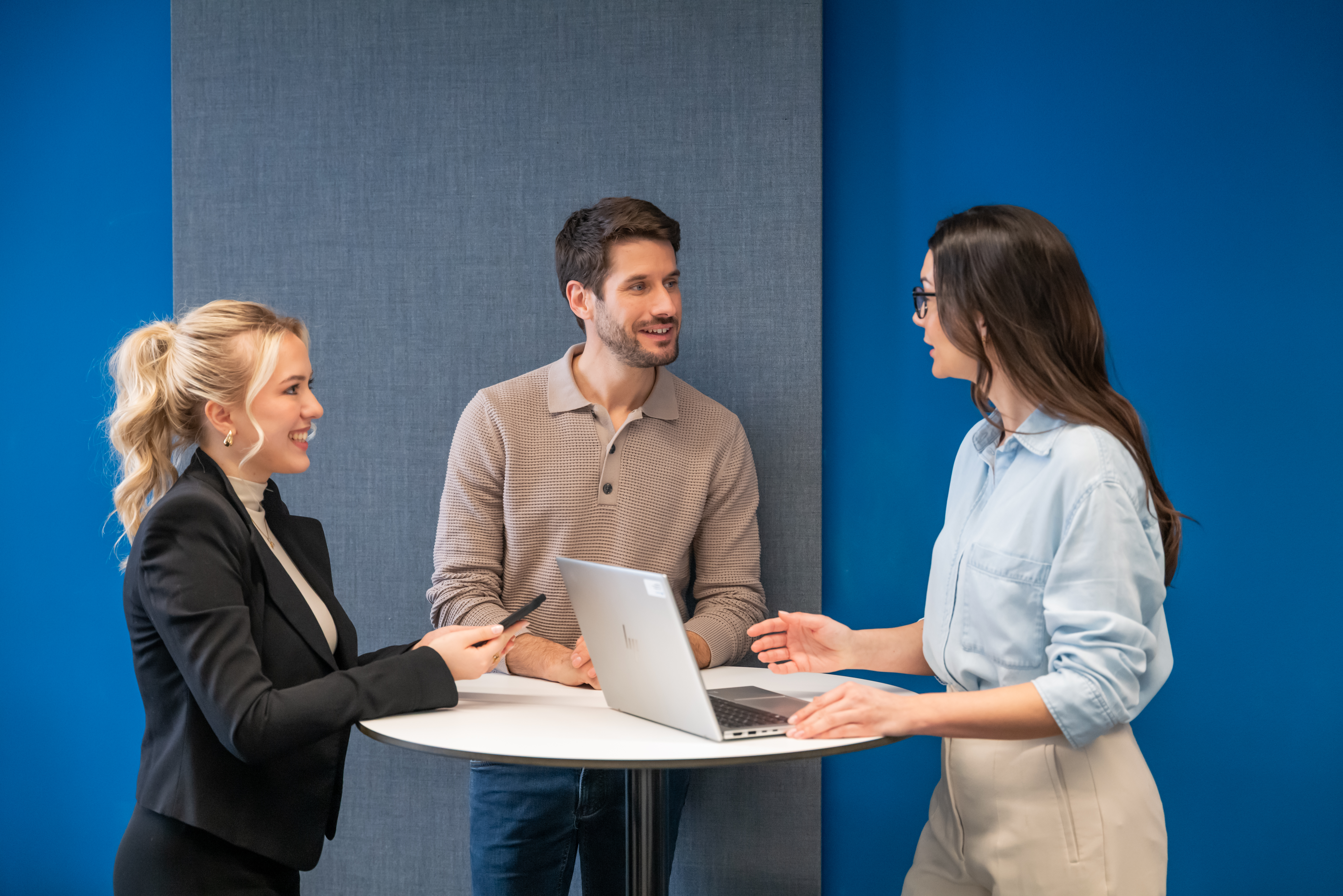 Drei Personen in Büro unterhalten sich